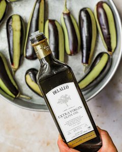 Pouring DeLallo Olive Oil on eggplants
