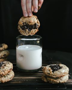 Cookie being dunked in milk