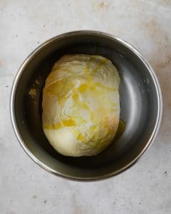 dough in stainless steel bowl with olive oil