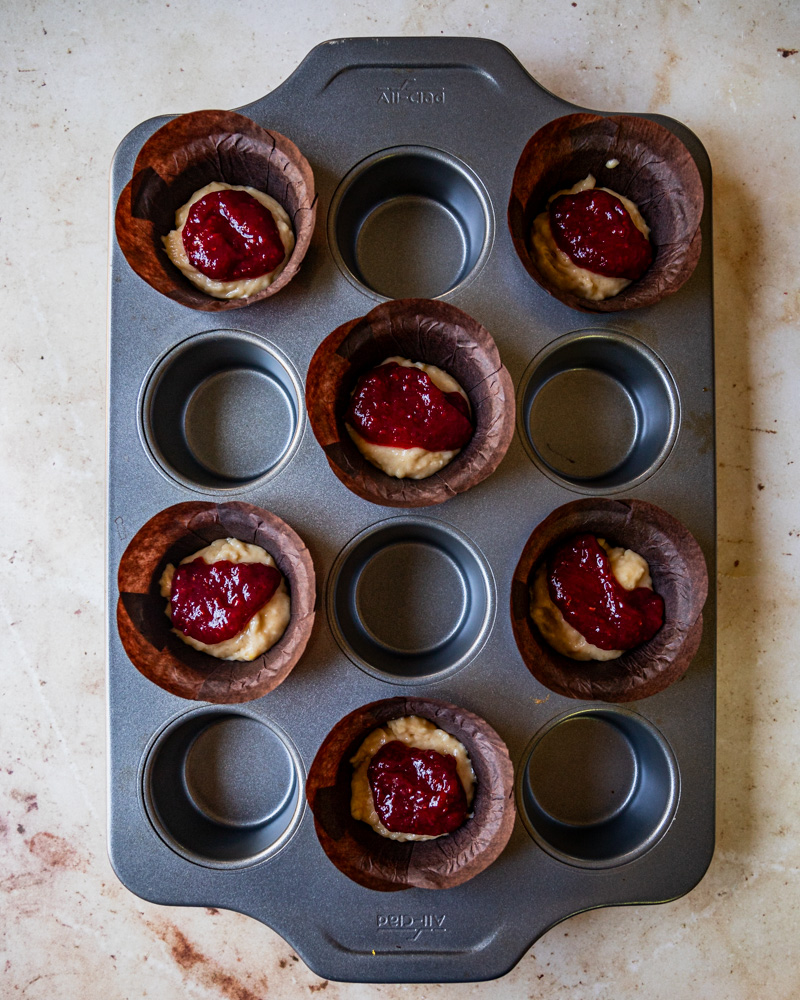 batter and jam in muffin liners