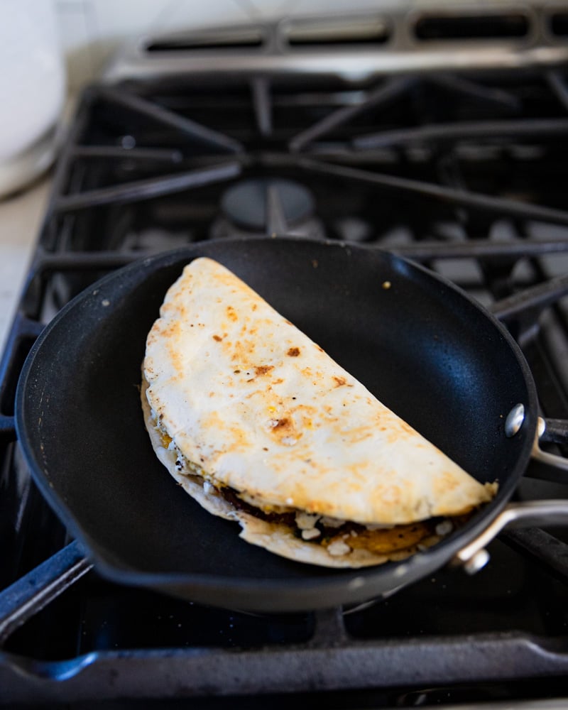 tortilla folded in half in skillet